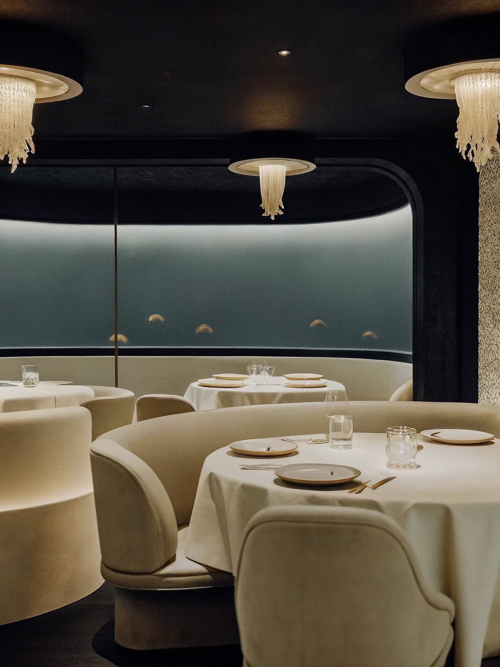 A long table laid for service, glassware catching the window light.